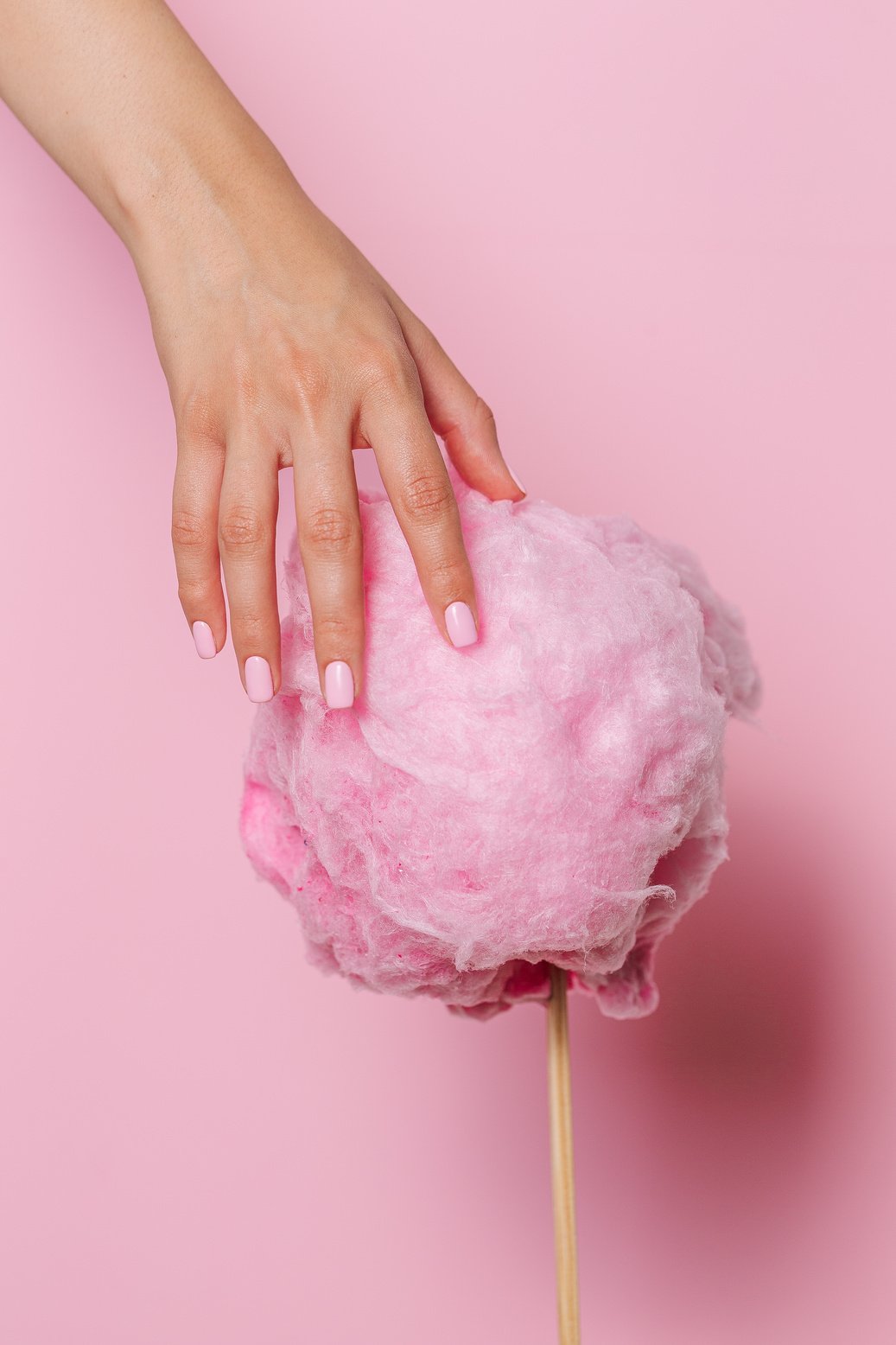 Hand Touching a Pink Cotton Candy 